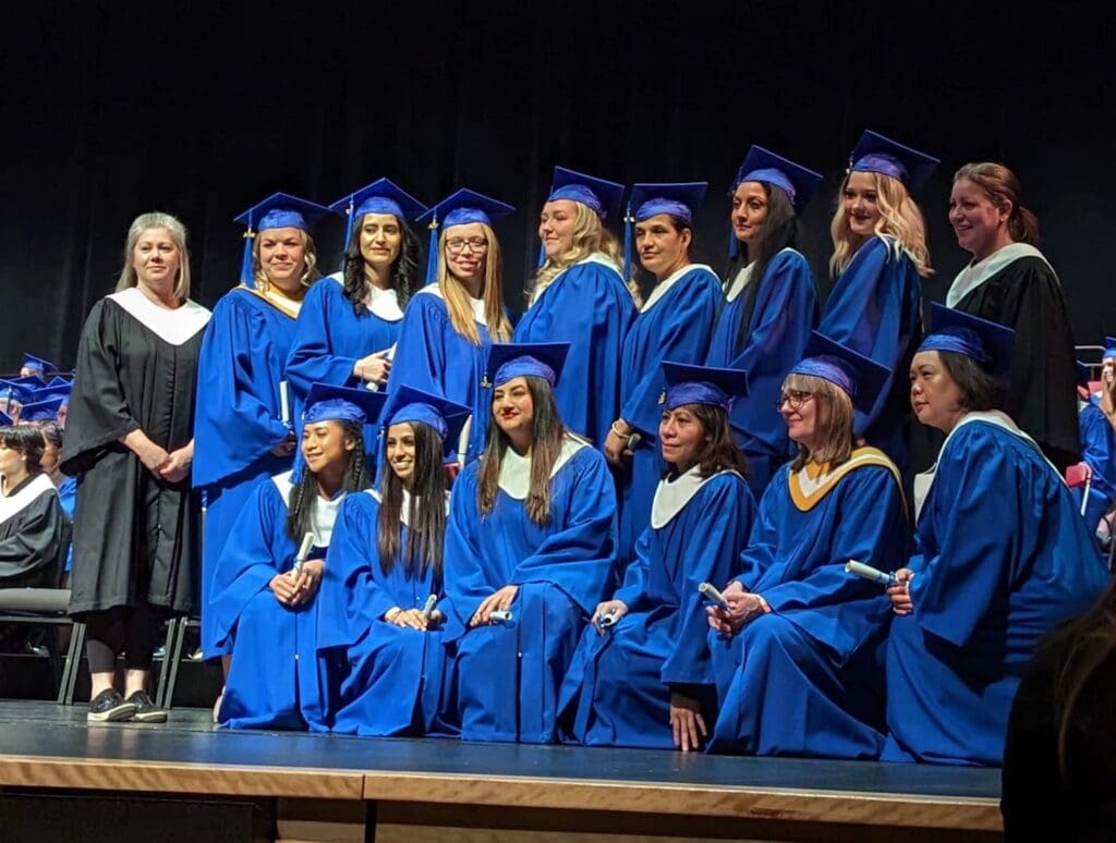 Carol Mohanraj and her peers pose for a photo at their graduation ceremony.