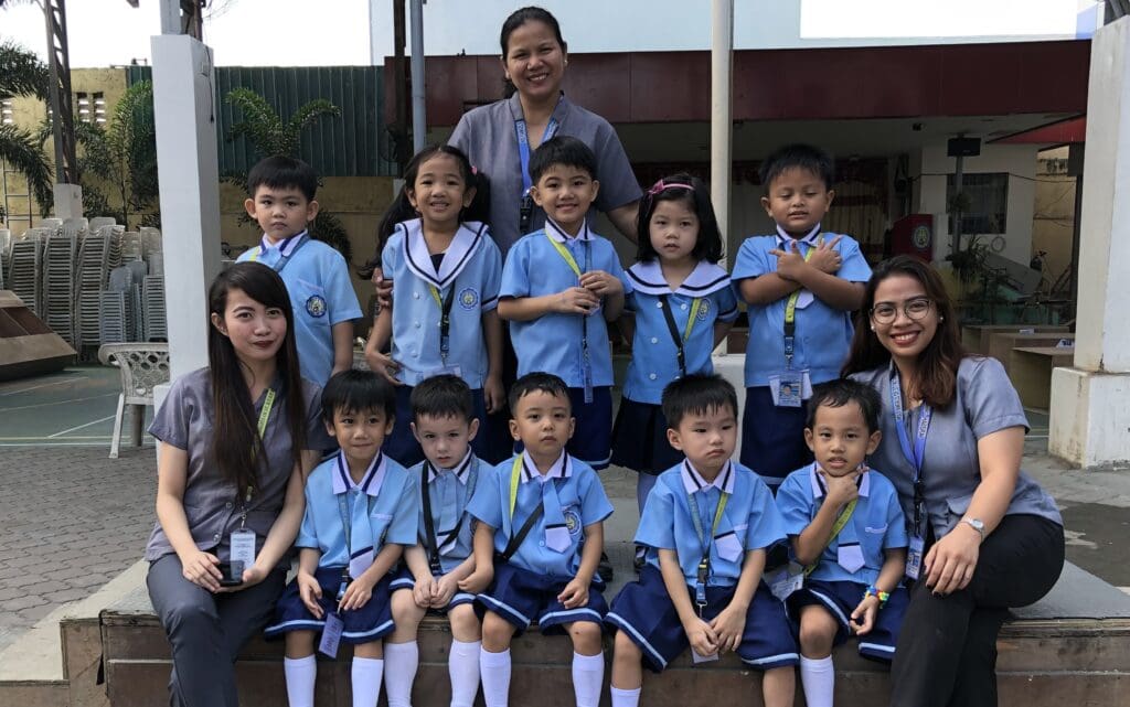 Mavy Alisian Alvarez with her preschool class and colleagues in the Philippines.