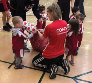 Maddie as a coach surrounded by children. Being a coach taught her how to communicate with kids and be creative.