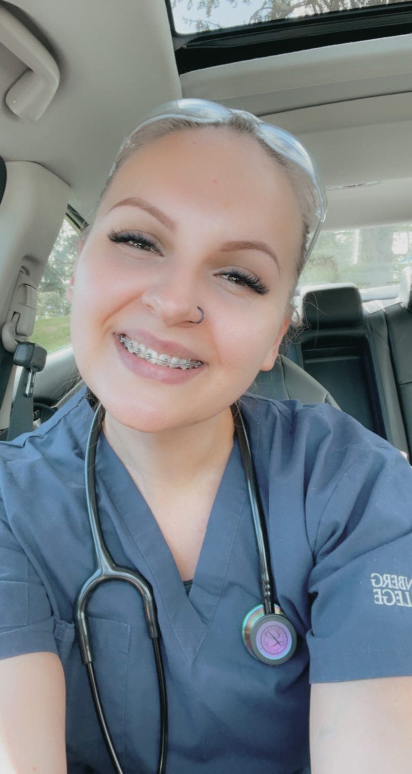 A selfie of Oksana smiling in her scrubs, after her first clinical experience.
