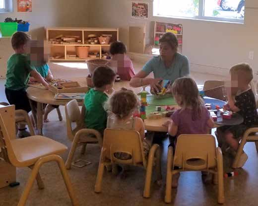 Simrajit sits on a table surrounded by kids eager to learn from her.