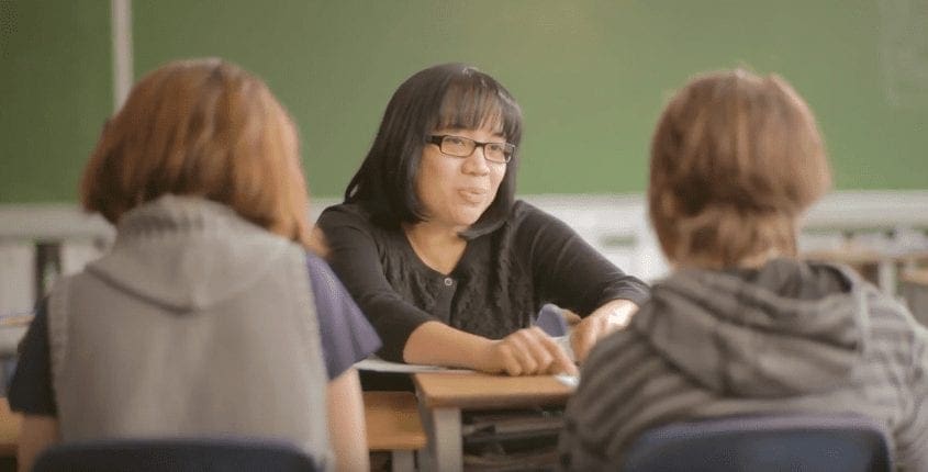 Maricar helping students in a classroom.